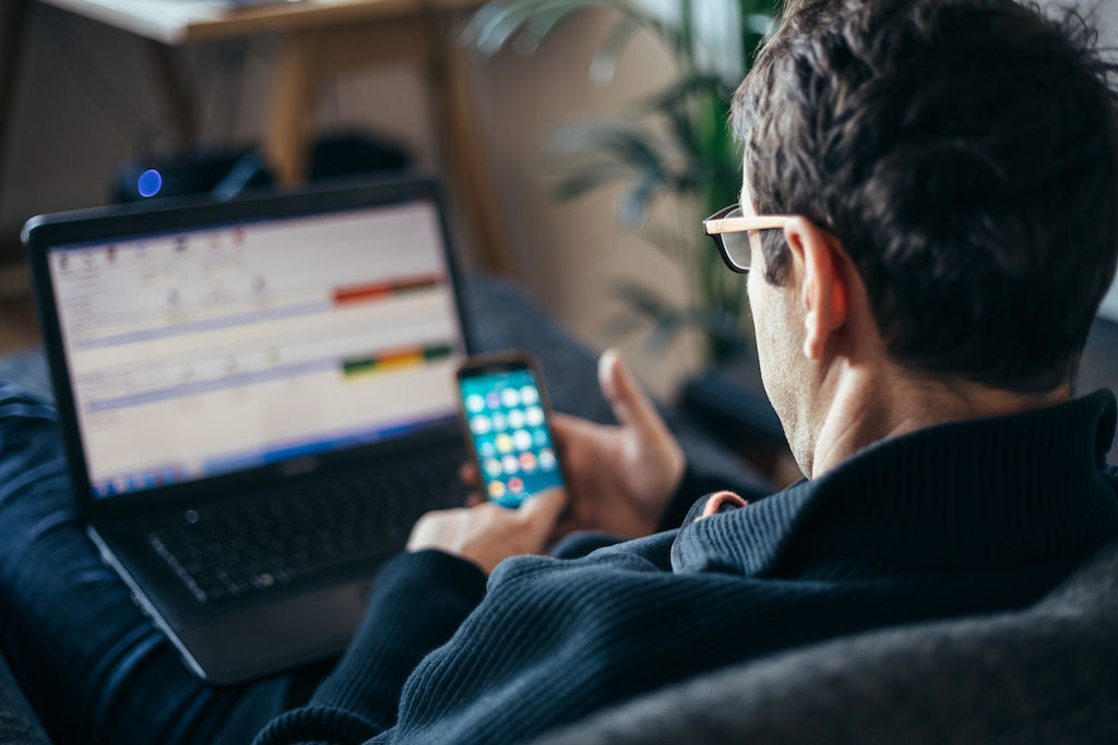 Man texting in front of computer